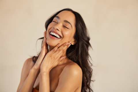Multiethnic,Young,Woman,Touching,Her,Clean,And,Healthy,Face,Against