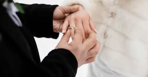groom-is-putting-wedding-ring-hi