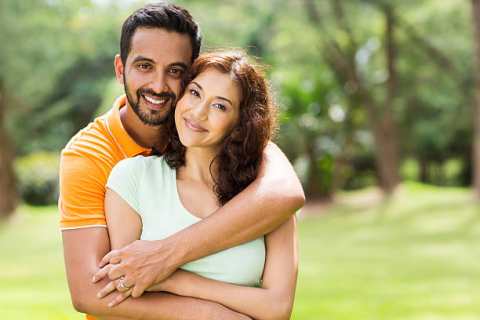 lovely young indian couple hugging outdoors